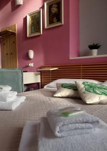 Un dormitorio con paredes rosas y una cama con toallas. en Hotel Serena, en Arenzano