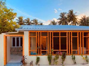 ein Haus mit einem Sonnendach darüber in der Unterkunft Surf Trip Maldives in Thulusdhoo
