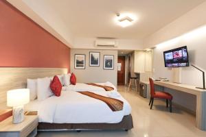 a hotel room with a bed and a desk and a television at Tubtim Siam Suvarnabhumi Hotel in Bang Phli