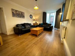 a living room with a couch and a coffee table at Roker Cottage, luxury seaside apartment, private parking, sky tv in Sunderland