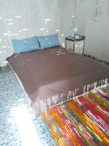 Michael's House في Nuweiba: غرفة نوم مع سرير وبطانية ملونة