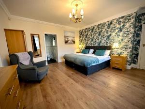 um quarto com uma cama e uma cadeira em Roker Cottage, luxury seaside apartment, private parking, sky tv em Sunderland