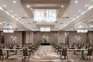 un gran salón de banquetes con mesas y un podio en Palm Beach Gardens Marriott, en Palm Beach Gardens