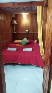 a bedroom with a bed with a red comforter at Willkommen im Paradies - Welcome in Paradise - Bienvenidos al paraíso in La Matanza de Acentejo