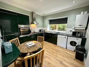 a kitchen with a table and a kitchen with a washer at Roker Cottage, luxury seaside apartment, private parking, sky tv in Sunderland