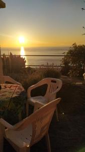 een tafel en stoelen met de zonsondergang op de achtergrond bij Willkommen im Paradies - Welcome in Paradise - Bienvenidos al paraíso in La Matanza de Acentejo