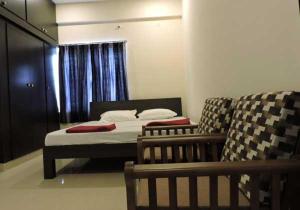 niewielka sypialnia z łóżkiem i kanapą w obiekcie SAN DE Stay and Banquet Hall w mieście Selam
