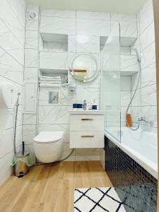 華沙的住宿－Apart Wiktoria，白色的浴室设有卫生间和水槽。
