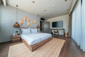 a bedroom with a large bed and a flat screen tv at KHAI HOTEL BODRUM in Bodrum City