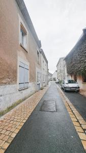 an empty street with a car parked next to a building at Gite étape pour amoureux du vélo Azay centre 12p. in Azay-le-Rideau