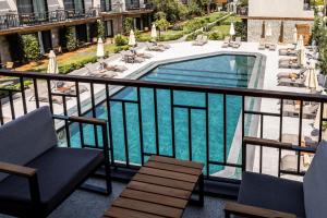 uma vista para uma piscina a partir de uma varanda em KHAI HOTEL BODRUM em Bodrum City