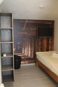 ein Schlafzimmer mit einem Bett und einem TV an der Wand in der Unterkunft Hotel Duwakschopp in Herxheim
