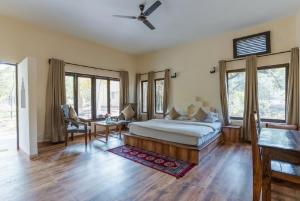 a bedroom with a bed and a table and chairs at Jungle King Resort in Kānha