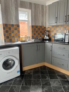 a kitchen with a sink and a washing machine at Charlies in Skegness
