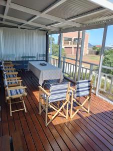 eine Veranda mit einem Tisch und Stühlen auf einer Terrasse in der Unterkunft Cottage Amnesia in Bettyʼs Bay