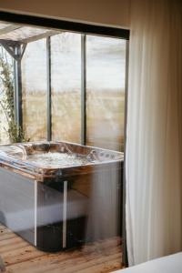 a bath tub sitting in front of a window at Lux in the garden Komárno 