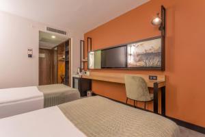 a hotel room with two beds and a desk at Best Western Plus Khan Hotel in Antalya