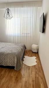Schlafzimmer mit einem Bett, einem TV und Holzböden in der Unterkunft New modern accommodation in city in Metković