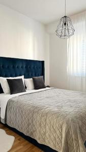 a bedroom with a large bed with a blue headboard at New modern accommodation in city in Metković