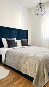 a bedroom with a large bed with a blue headboard at New modern accommodation in city in Metković