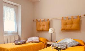 two beds in a room with yellow sheets at Matteo's House in Penne