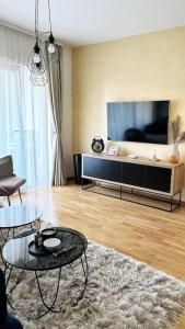 ein Wohnzimmer mit einem TV und einem Tisch in der Unterkunft New modern accommodation in city in Metković