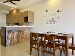 a kitchen with a wooden table and some stools at Sunset view Homestay near Lake Garden w/ Swimming pool in Taiping