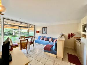 a living room with a blue couch and a table at Appartement Nice aéroport seafront with pool in Cros-de-Cagnes