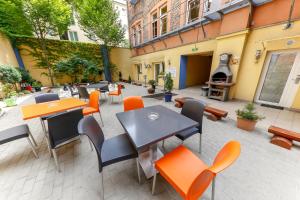 un patio al aire libre con mesas, sillas y chimenea en Do Step Inn Home - Hotel & Hostel, en Viena