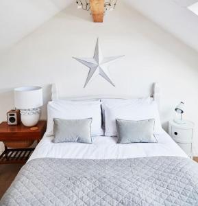 ein Schlafzimmer mit einem weißen Bett mit einem Stern darüber in der Unterkunft 3 bedroom converted chapel in historic Oundle in Oundle