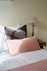 a pile of pillows sitting on top of a bed at 3 bedroom converted chapel in historic Oundle in Oundle