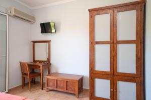 Habitación con puerta, mesa y espejo en Aggelina's Apartments, en Xi