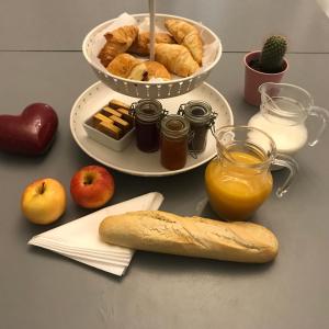 uma mesa com um prato de pão e um prato de pastelaria em Une Pause Douceur - Suite All in Wood em Eyguières