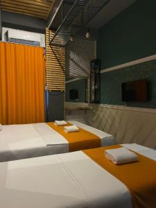 two beds in a room with orange and white at Hotel In Time in Prizren