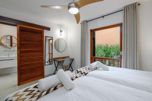 ein Schlafzimmer mit einem großen weißen Bett und einem Fenster in der Unterkunft San Lameer Villa 1933 - 2 Bedroom Classic - 4 pax - San Lameer Rental Agency in Southbroom + 15 Fotos