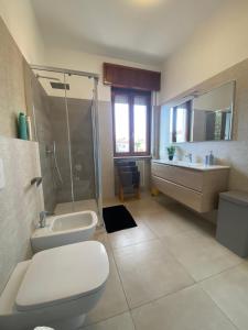 a bathroom with a toilet and a sink and a shower at Appartamento La finestra sul Parco in Dalmine +19 photos