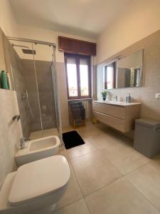 a bathroom with a toilet and a shower and a sink at Appartamento La finestra sul Parco in Dalmine
