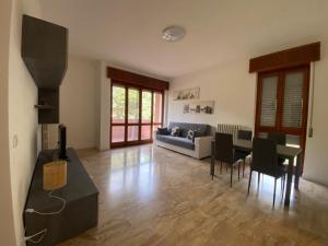 a living room with a couch and a table and chairs at Appartamento La finestra sul Parco in Dalmine