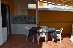 a table and chairs in a kitchen with a table and a counter at Relax in Casa Domi in Scalea