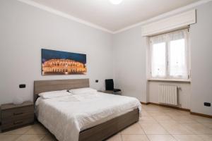 a white bedroom with a large bed and a window at Appartamento Scaligero in Verona