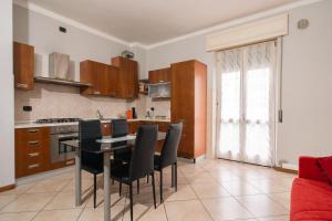 a kitchen with a table and black chairs in it at Appartamento Scaligero in Verona