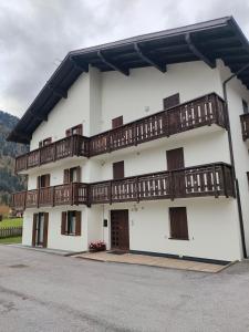 a white building with wooden balconies on it at Pinzolocasa in Pinzolo