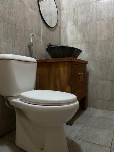 La salle de bains est pourvue de toilettes blanches et d'un miroir. dans l'établissement Mara Safari Lodge Kidepo, 