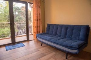 een blauwe bank in een kamer met een groot raam bij Private home in Flic en Flac - quiet location in Flic-en-Flac