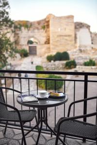 a table and chairs on a balcony with a view of a building at Kallinos Boutique Hotel in Selcuk