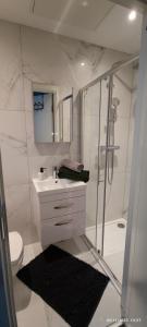 a white bathroom with a sink and a shower at Studio Flat / London Gateway in Borehamwood