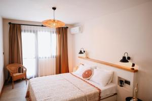 a bedroom with a bed and a large window at Kallinos Boutique Hotel in Selçuk