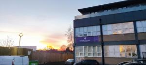 a building with a purple sign on the side of it at Studio Flat / London Gateway in Borehamwood