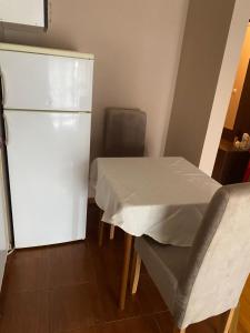 a small kitchen with a table and a refrigerator at Stan blizu izlaza na autoput in Mali Mokri Lug