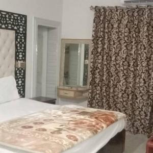 una camera da letto con un letto e una finestra con una tenda di Bodla Royal Hotel a Multan